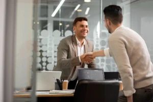 Cliente y consultor sellando un acuerdo con un apretón de manos.
